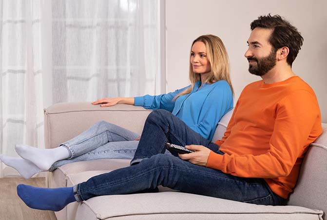 Zwei Personen sitzen auf einem Sofa.