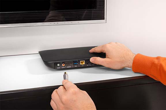 Hand mit TV-Kabel am Receiver