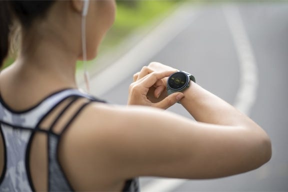 Frau trägt Smartwatch beim Joggen