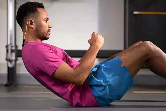 Mann macht Sit-Ups mit Kopfhörern von Hama
