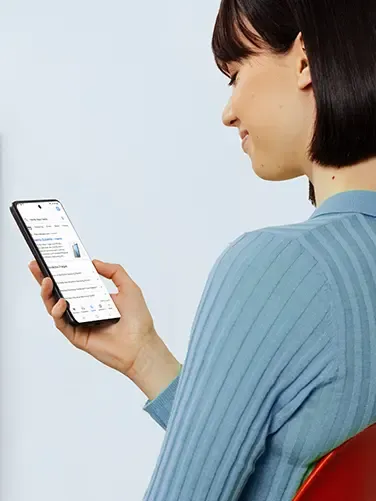 Frau hält ein Smartphone in der Hand, auf dem eine Produktwebseite angezeigt wird, und betrachtet den Bildschirm