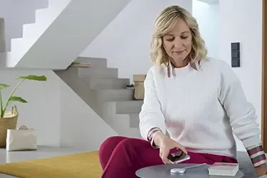 Person lädt iPhone auf einer induktiven Ladestation