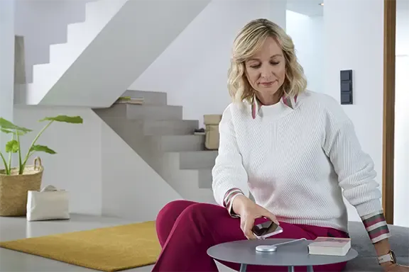 Person lädt iPhone auf einer induktiven Ladestation