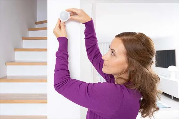 Bewegungsmelder wird an der Wand befestigt.