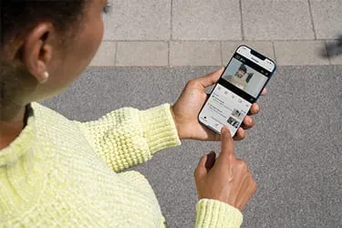 Frau greift via Smartphone auf Überwachungskamera zu