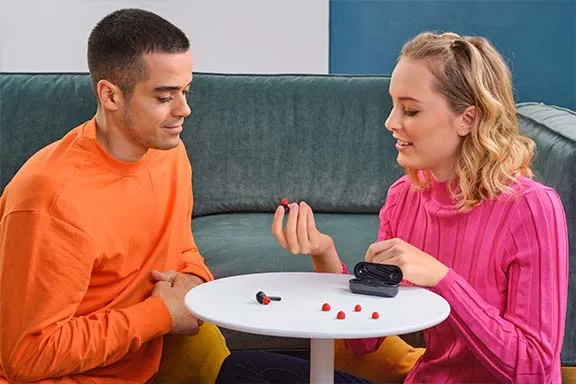 Mann und Frau sprechen über In-Ear Kopfhörern
