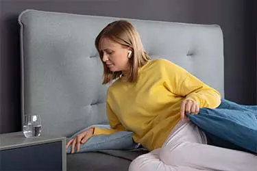 Person mit kabellosen Kopfhörern beim Bettgehen.