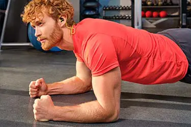 Person nutzt Sport-Kopfhörer Active BT im Fitnessstudio.