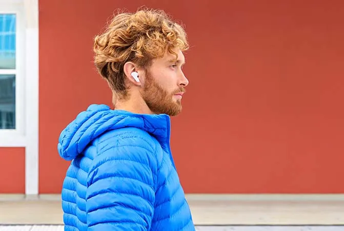 Mann mit blauer Jacke trägt kabellose Bluetooth-Kopfhörer von Hama