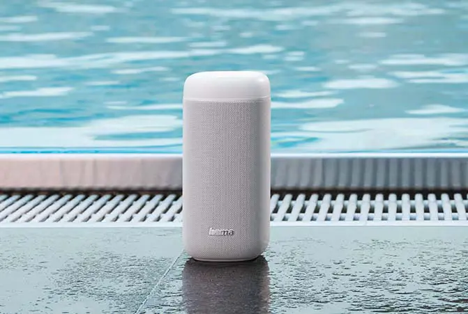 Weißer kabelloser Outdoor-Lautsprecher von Hama steht am Rand eines Schwimmbeckens
