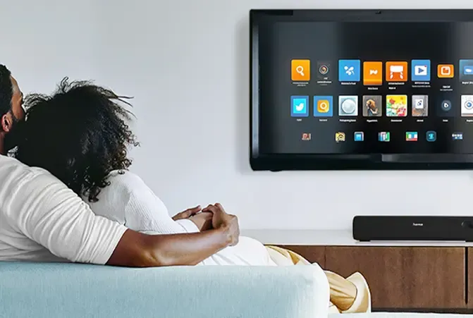 Pärchen sitzt gemeinsam vor einem alten Fernseher