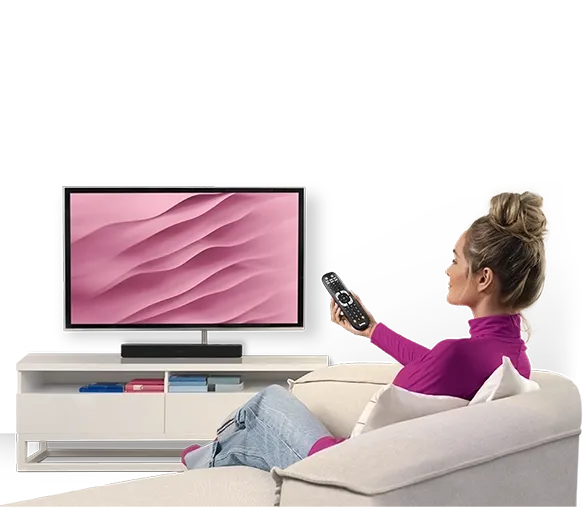 Person sitzt auf Sofa und bedient Fernseher mit Fernbedieunung