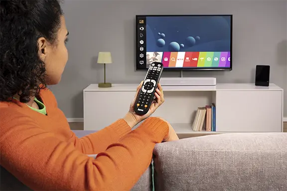 Person hält Universal-Fernbedienung für Fernseher in der Hand