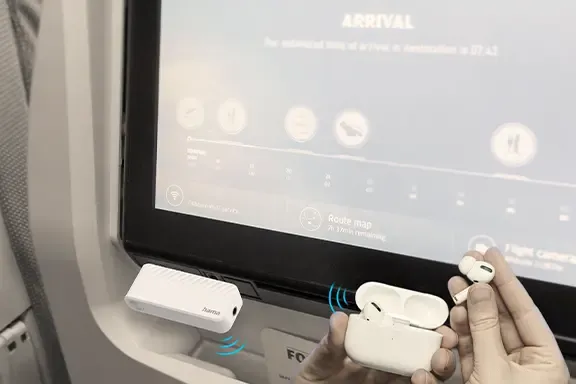 Person im Flugzeug verwendet Bluetooth-Kopfhörer mit Audio-Transmitter