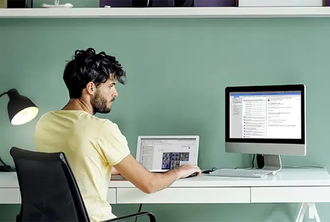 Mann sitzt an Homeoffice Arbeitsplatz.