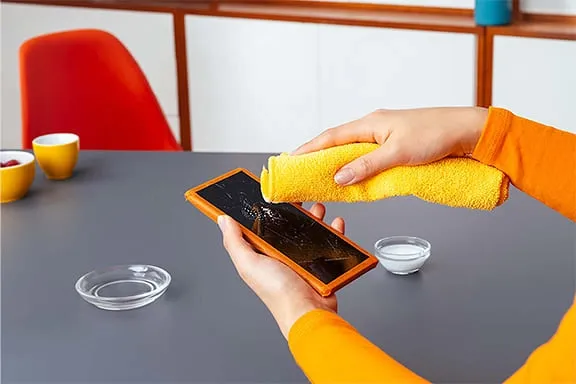 Mithilfe eines sauberen Mikrofasertuches wird der Display poliert