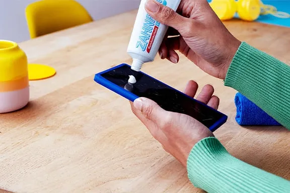 Zahnpasta auf Handy-Display auftragen