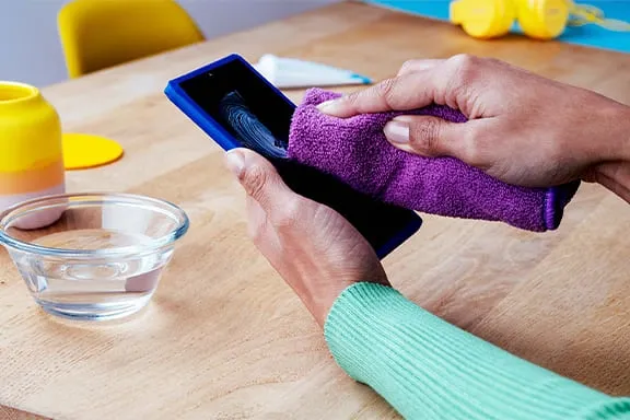 Handy-Display mit feuchtem Tuch säubern und Zahnpasta entfernen