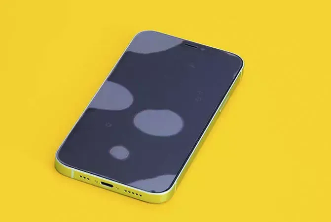 Smartphone liegt auf gelbem Untergrund und das Display ist zum Schutz mit Panzerglas ausgestattet, welches Luftblasen wirft
