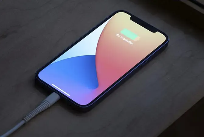 Handy wird über Nacht auf dem Nachttisch mit einem Kabel geladen
