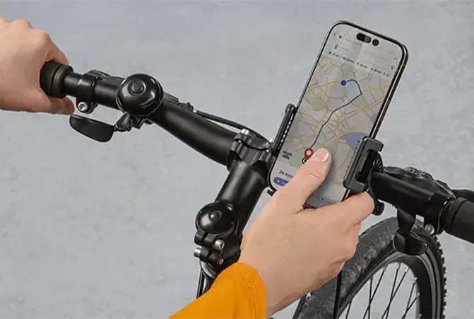 Person bedient Smartphone, welches am Fahrradlenker befestigt ist