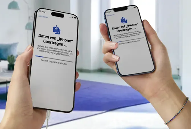 Person hält in beiden Händen jeweils ein Handy. Das Display zeigt an, dass Daten von einem Handy auf das andere übertragen werden