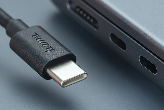 Schwarzes Hama Kabel mit USB-C Anschluss liegt direkt neben einem Notebook