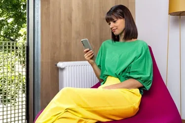 Person steuert die Heizung per App.