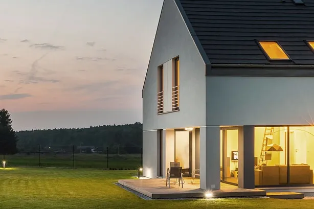 Einfamilienhaus bei Dämmerung, Lichter sind an