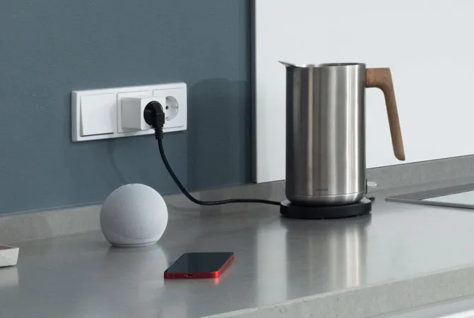 Das Handy liegt neben dem Echo Dot.