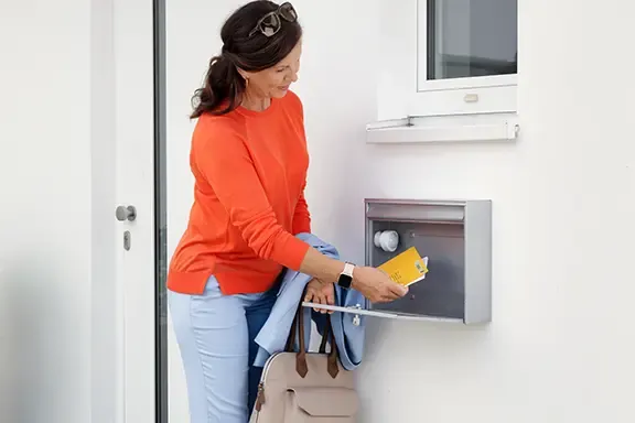 Person leert Briefkasten