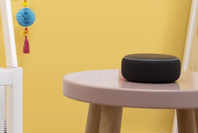Amazon Echo neben einem Babybett.