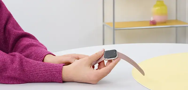 Person hält eine Apple Watch mit zerkratztem Display in der Hand.