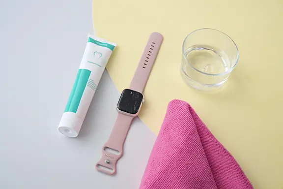Zahnpasta und Poliertuch liegen neben der Apple-Watch.