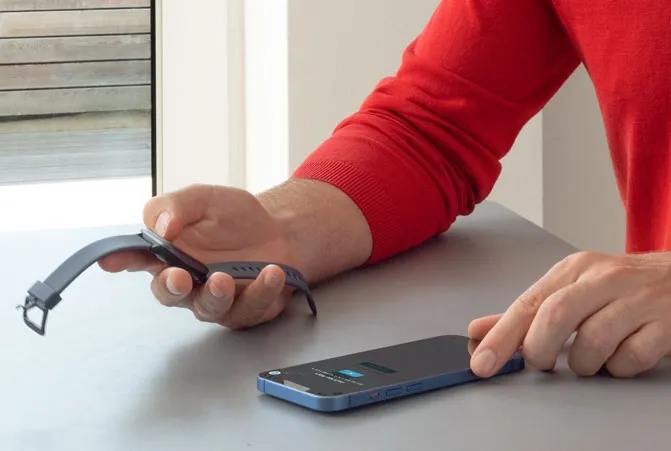 Das Handy liegt am Tisch und wird mit der Smartwatch verbunden. 