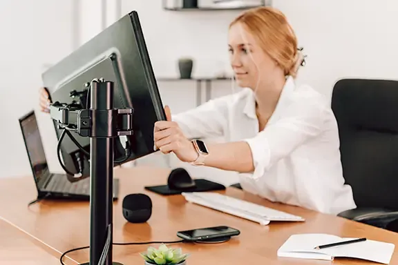 Person richtet den Monitor aus. Person richtet den Monitor aus.